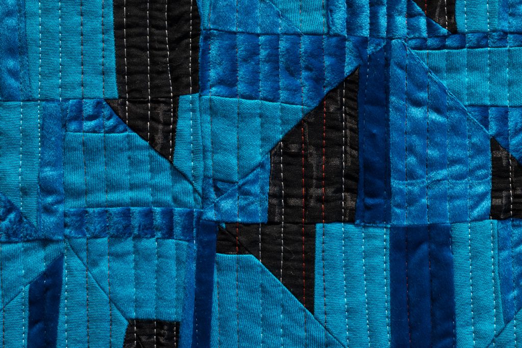 Upclose image of blue quilt.