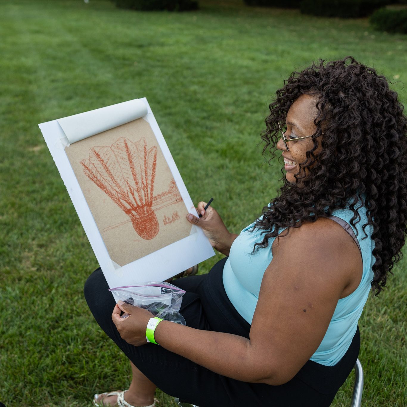 A Business Council member shows off her drawing of a Shuttlecock sculpture at a Nelson-Atkins Sketch Club event