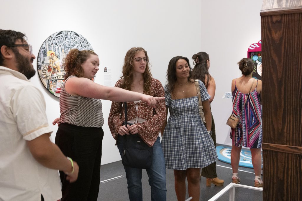 Three members of the Young Friends of Art interact with a work in an exhibition at the Nelson-Atkins.
