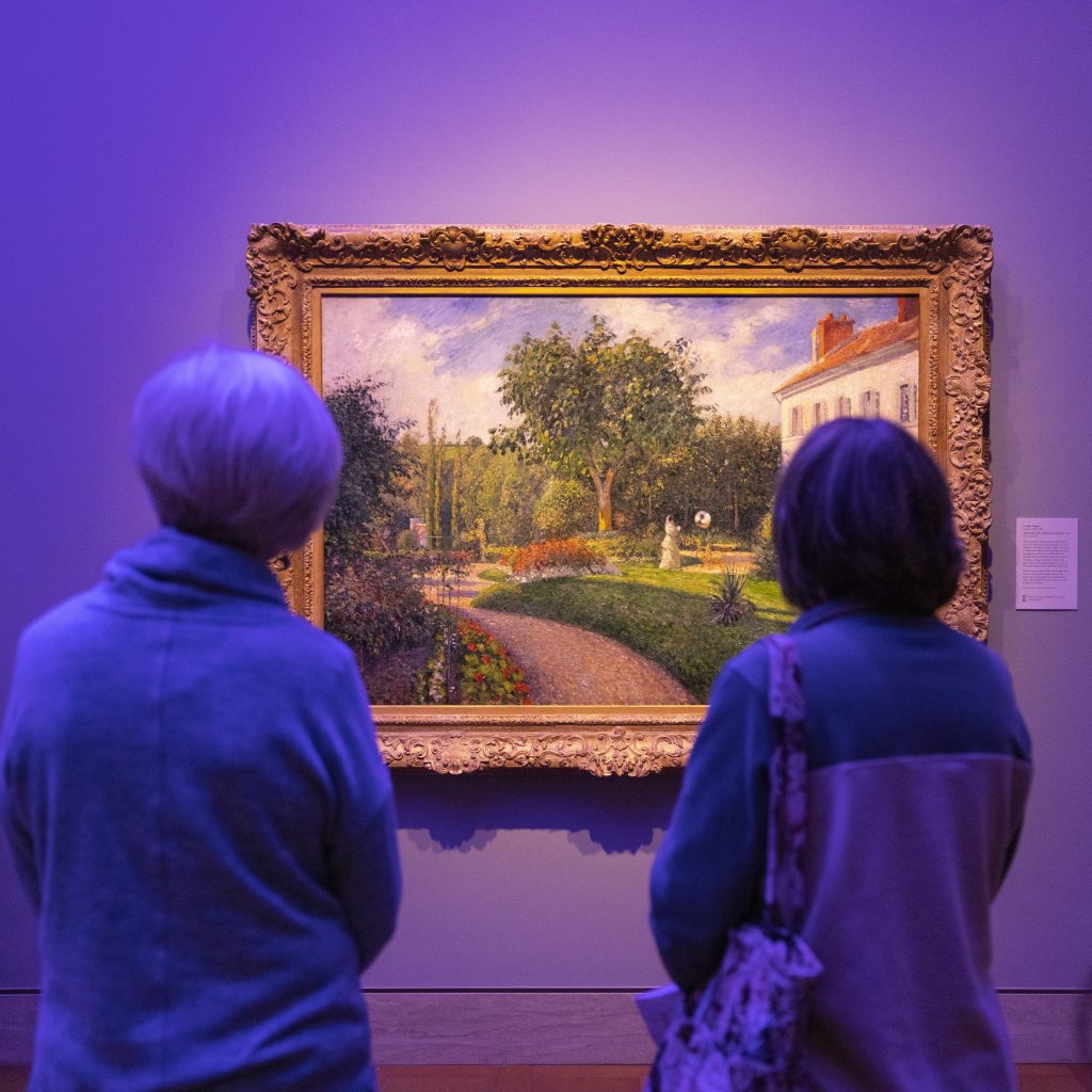 Guests gaze at an Impressionist painting during the colorful multisensory experience of A Beautiful Disruption.