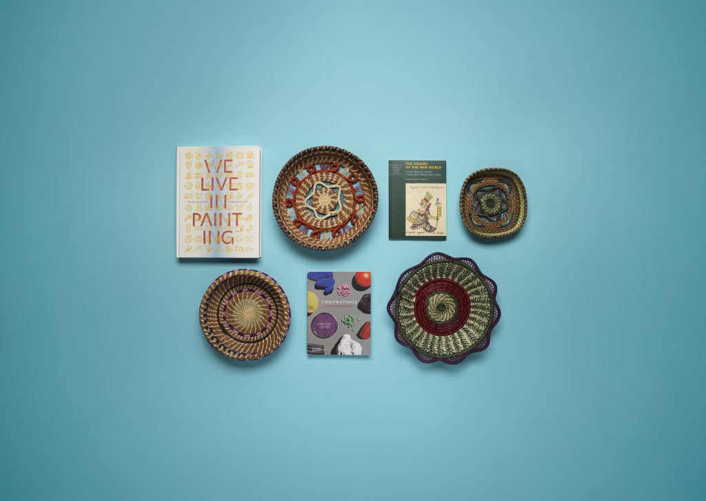 Items from the museum store on a blue background including book, bowls, and plates.