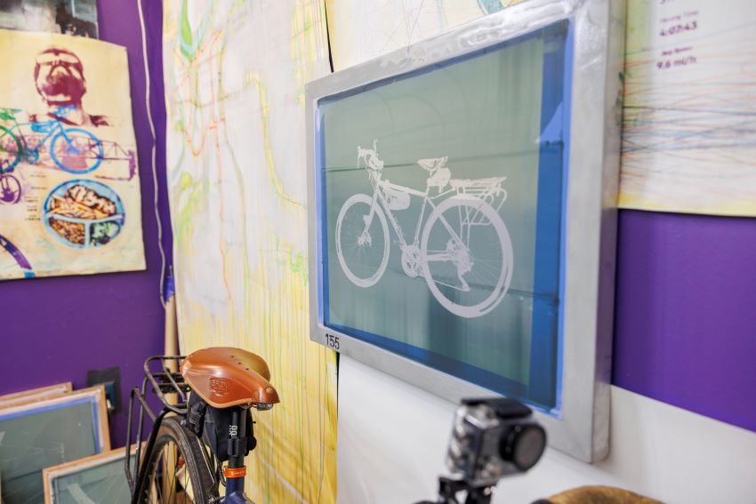 An image of a bike leaning against a wall with art of colorful bikes
