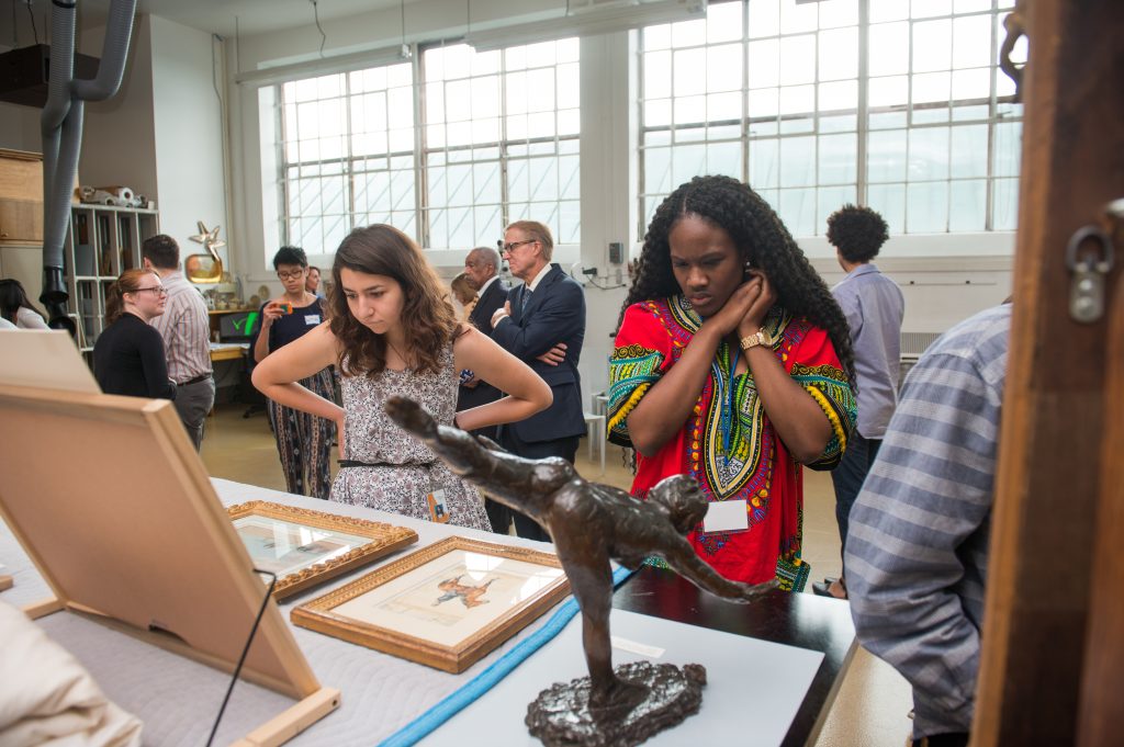 Interns look at new art acquisitions in the artist studio