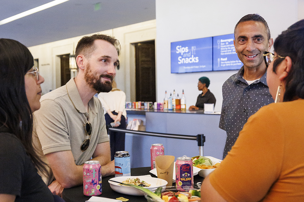 A group of four around a table smiling and talking
