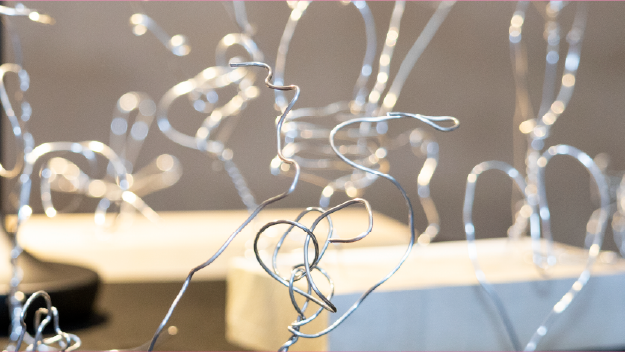 Colored pencils layed out over a drawing on paper.