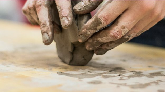 Art supplies ranging from scissors to colored pencils in varius cans.
