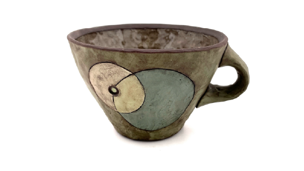 Multiple colors of pain on a table with pant brushes in them.