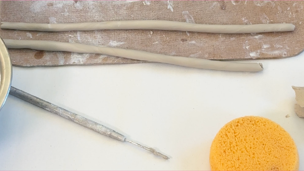 Multiple colors of pain on a table with pant brushes in them.