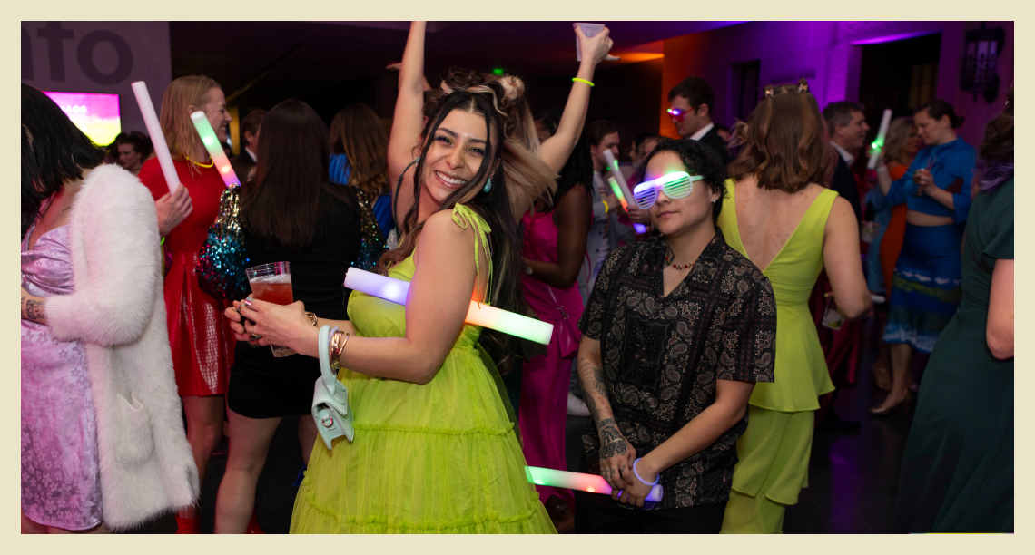 Two dancers with light up glasses and batons on the dancefloor.