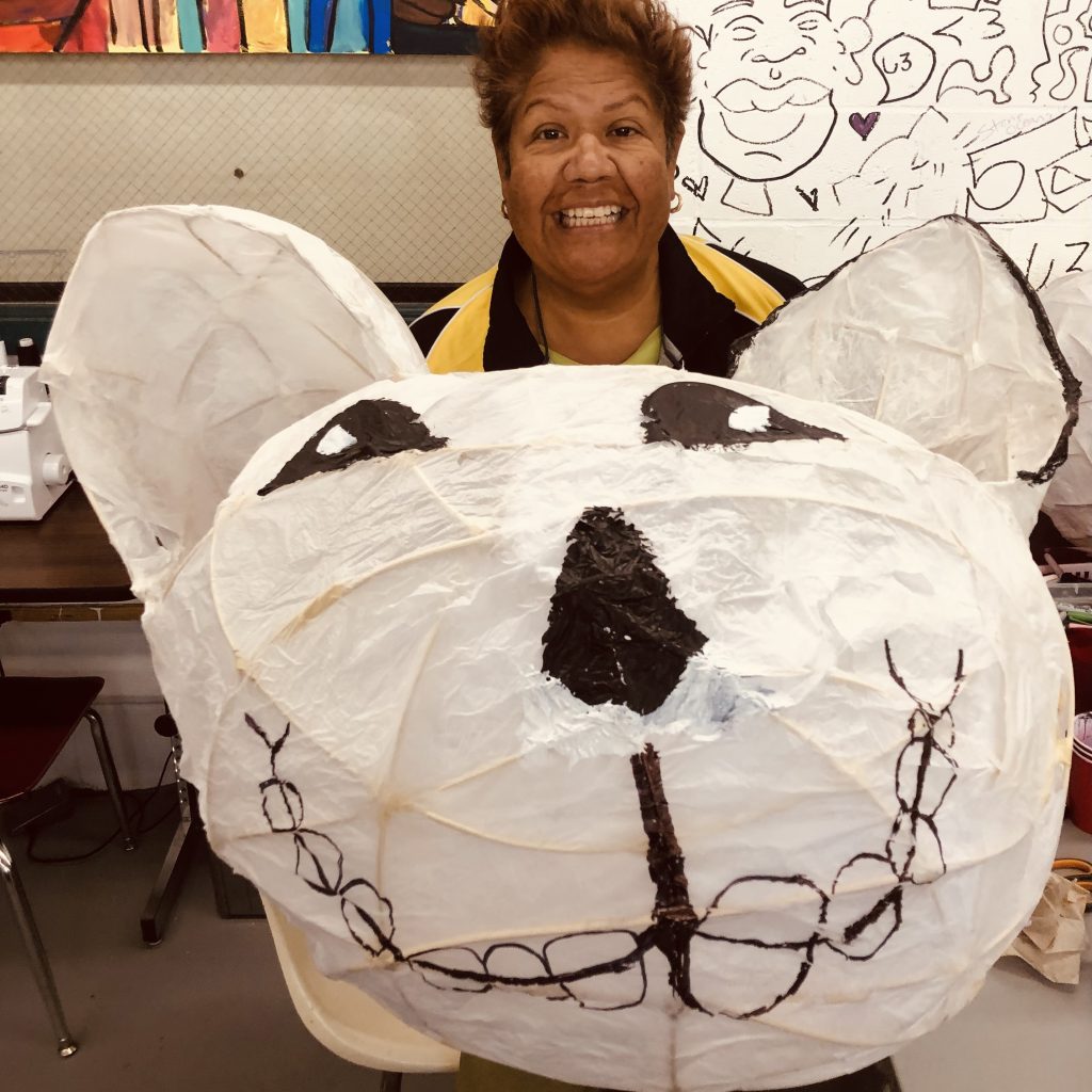 An artist displays a pinata shaped like a dog's head