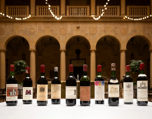 An image of 11 wine bottles on a white linen table