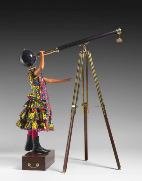 Art piece of mannequin with planet head staring through telescope