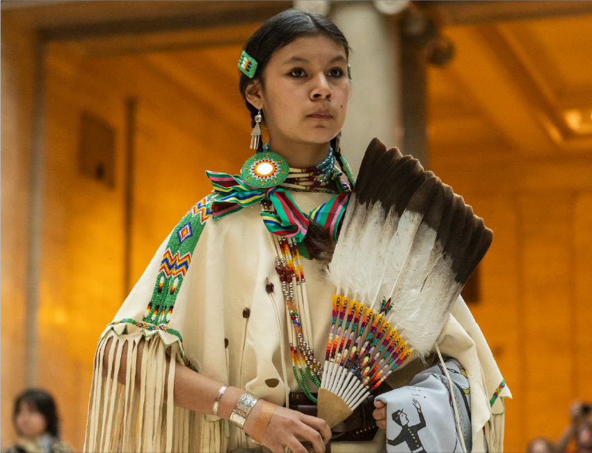 A performer holds a feather fan
