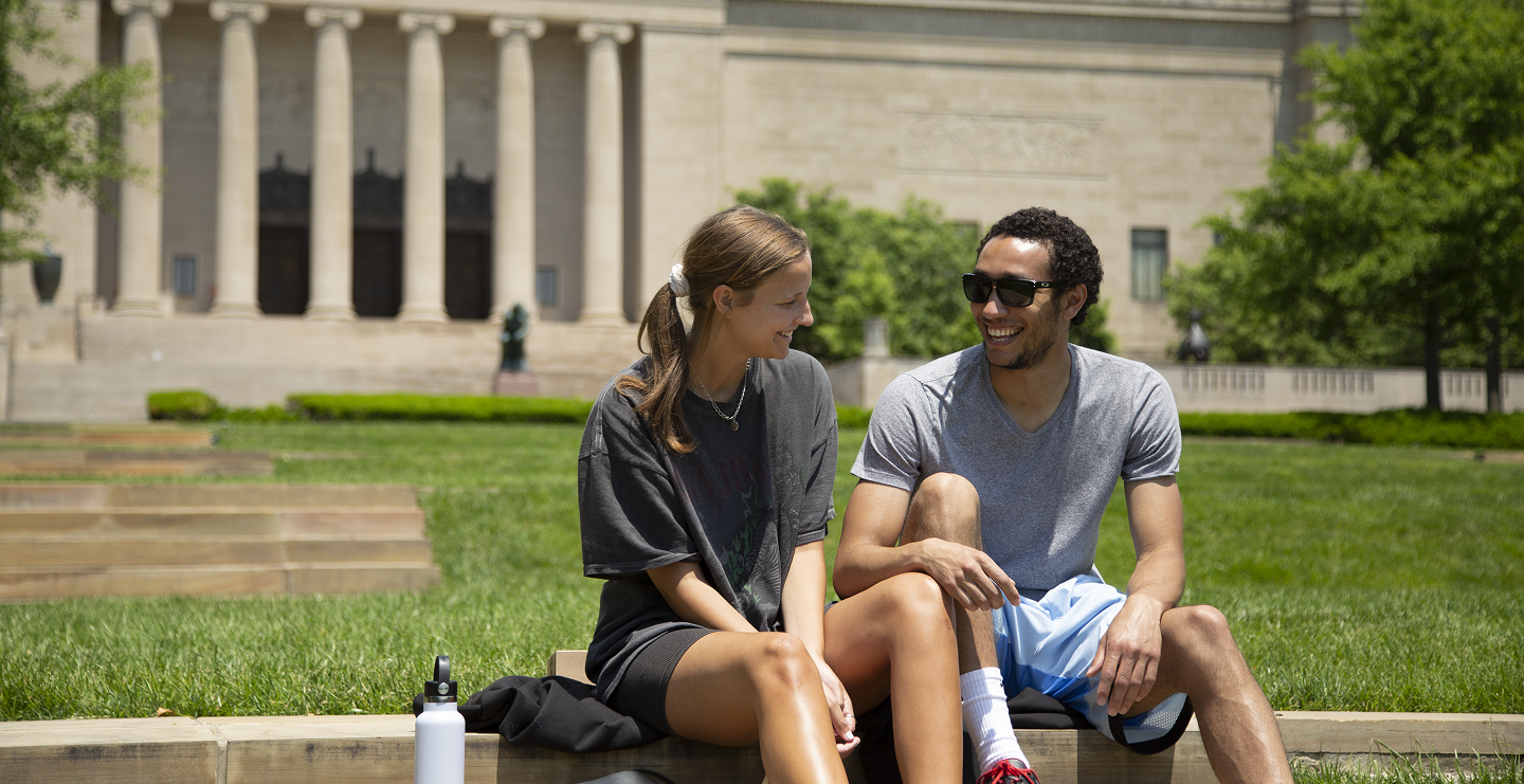 Two museum members sitting on the steps in the Sculpture Park.