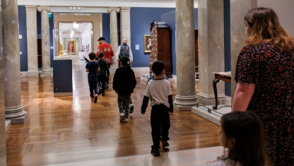 Multiple colors of pain on a table with pant brushes in them.