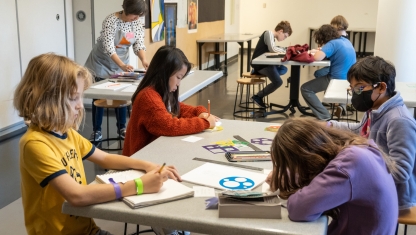 Art supplies ranging from scissors to colored pencils in varius cans.