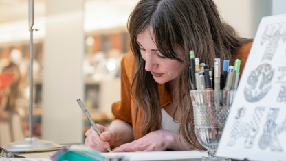 Art supplies ranging from scissors to colored pencils in varius cans.