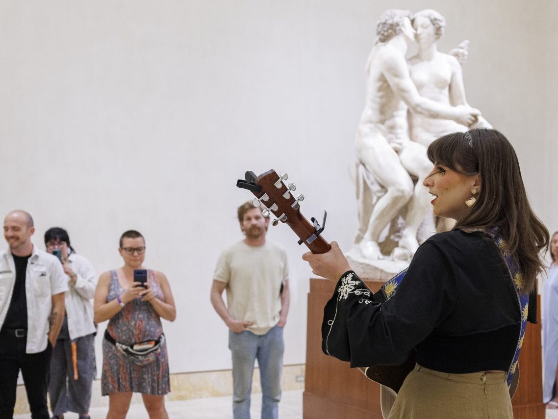 night shift second nature woman playing guitar in museum