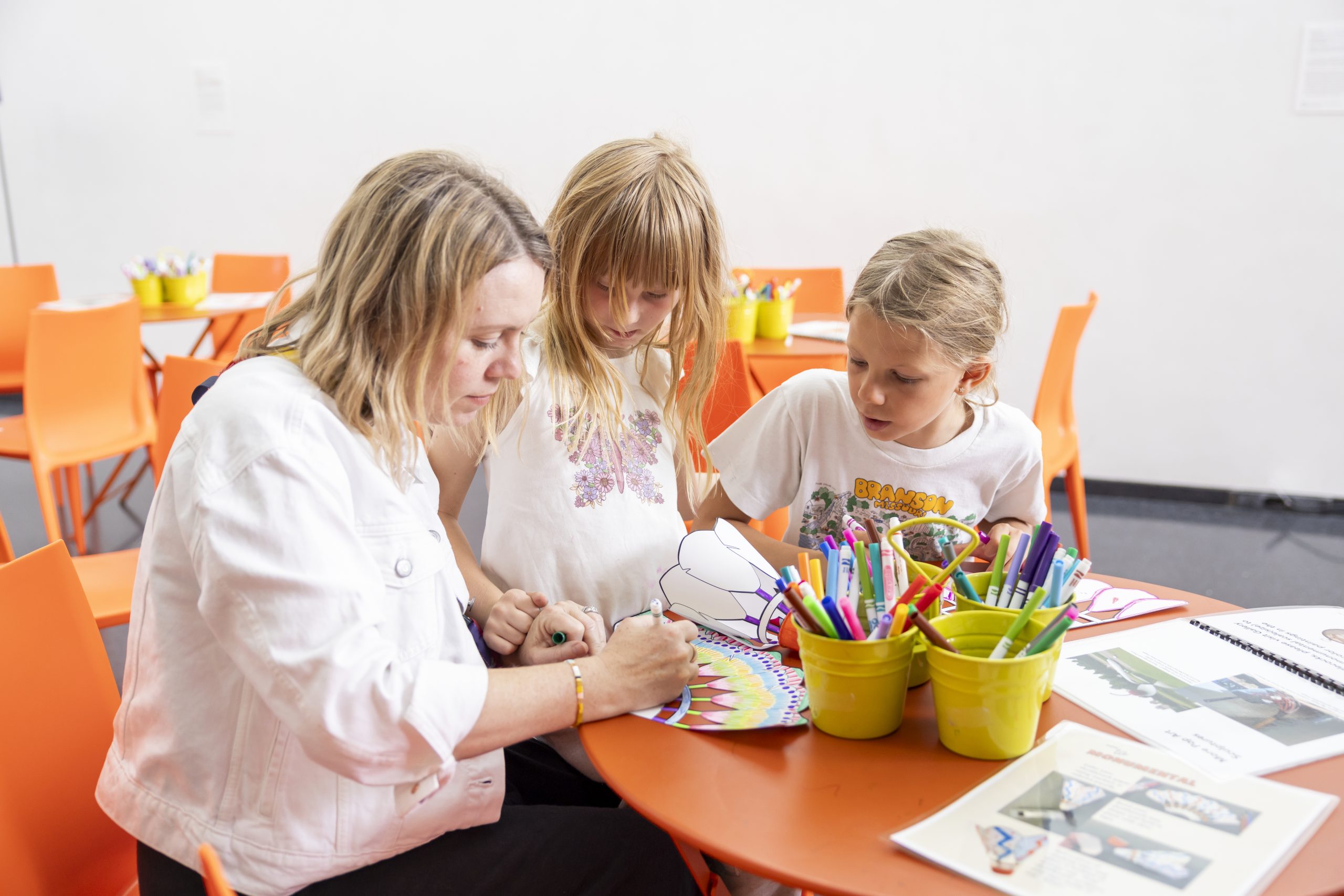 A Nelson-Atkins instructor offers activities to two children at a Free Weekend Fun event.